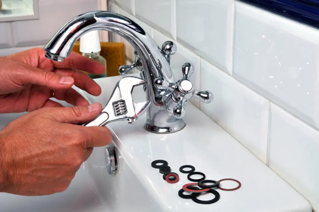Plumber performing maintenance on a bathroom faucet in Powder Springs