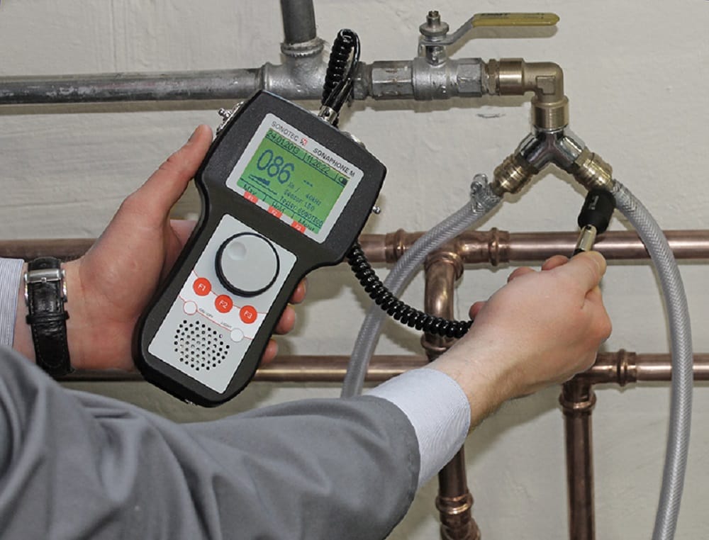 Plumber testing pipes with electronic leak detection equipment in Powder Springs