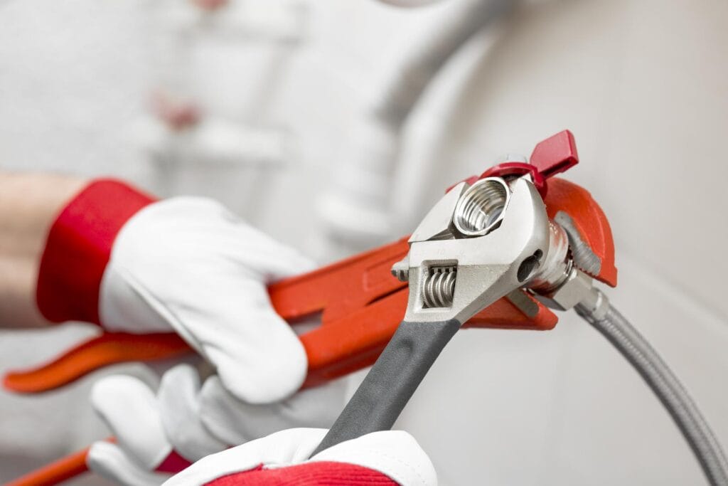 Plumber holding pipe wrenches for an emergency repair in Powder Springs