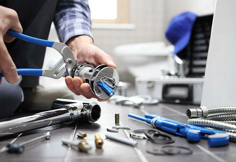 Technician repairing a plumbing fixture with professional tools in Powder Springs