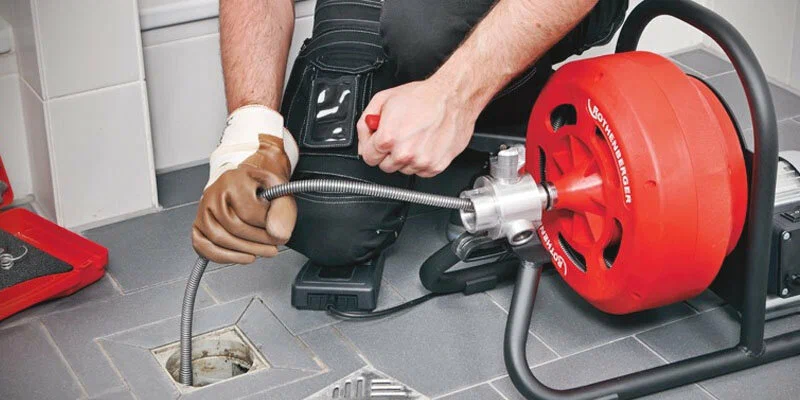 Plumber using a drain-cleaning machine in Powder Springs