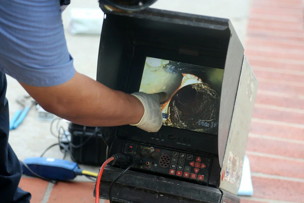 Technician viewing a drain inspection camera in Powder Springs