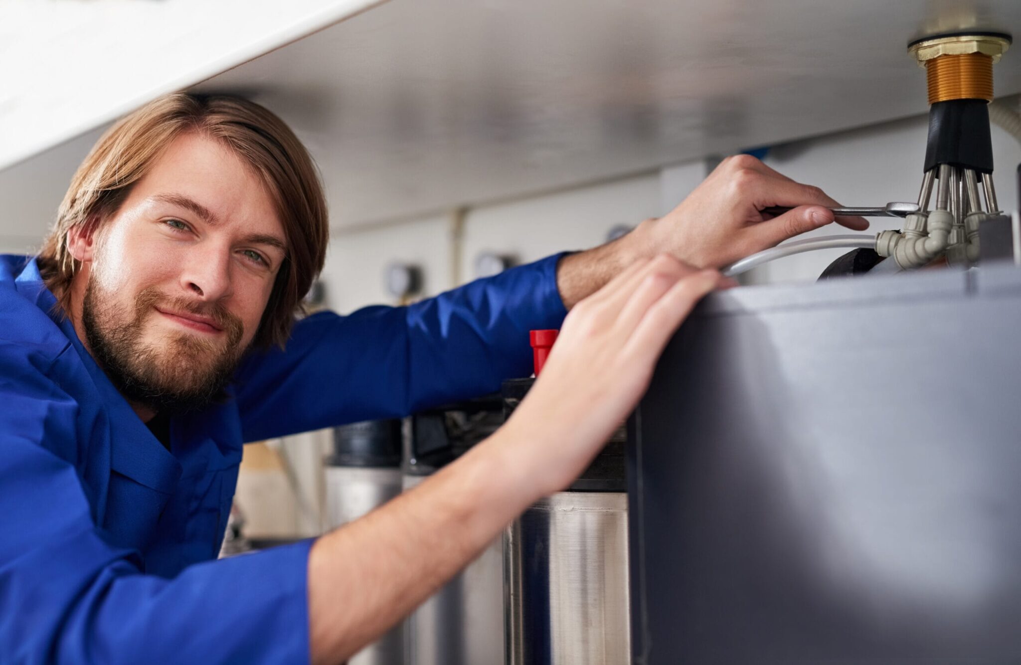 Technician servicing a residential water heater tank in Powder Springs